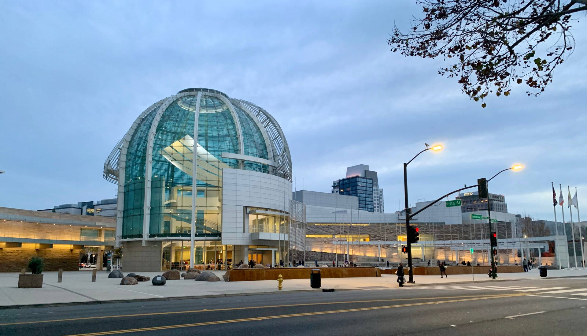 A Large Building With A Glass Roof And A Street Background