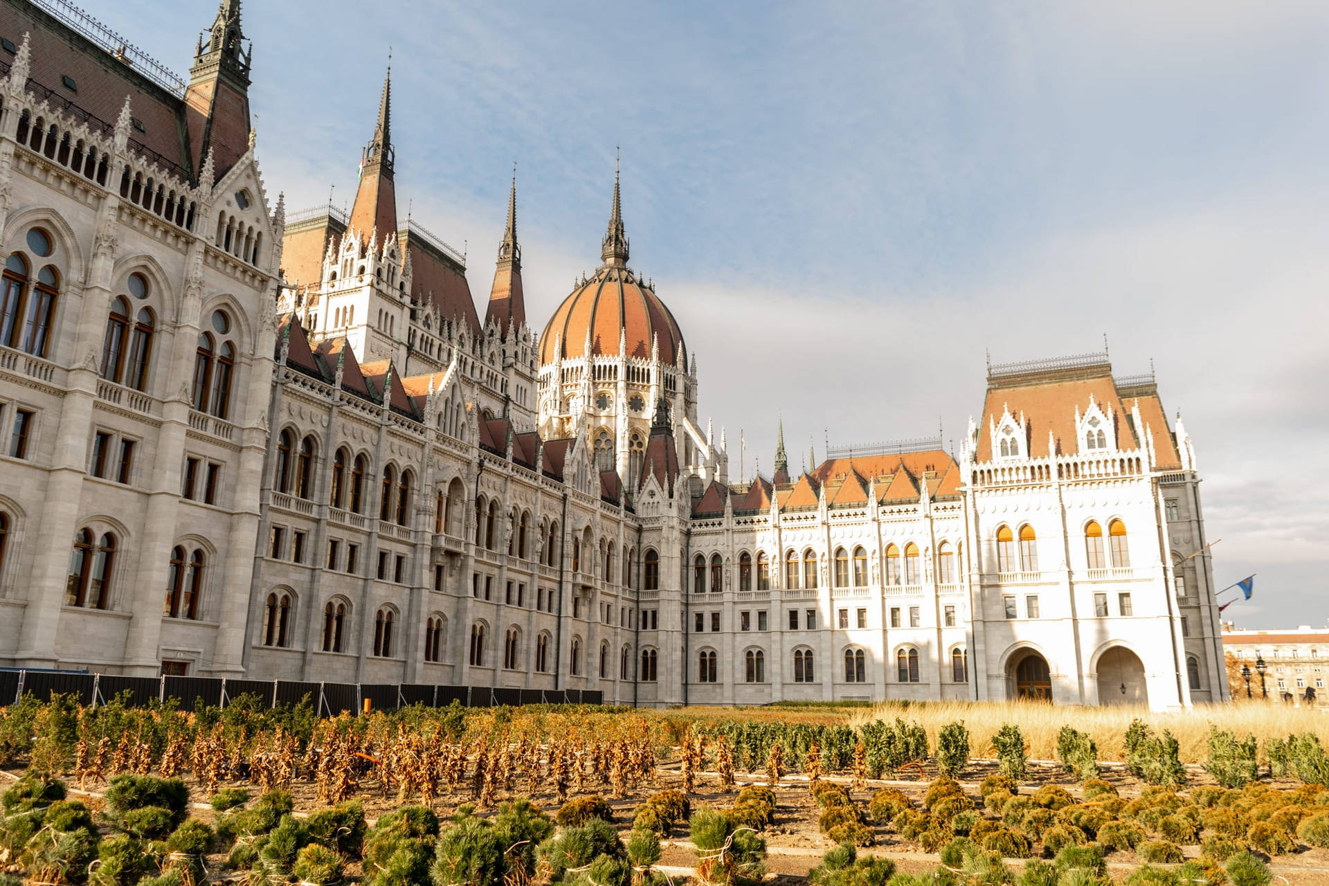 A Large Building With A Large Garden In Front Of It Background