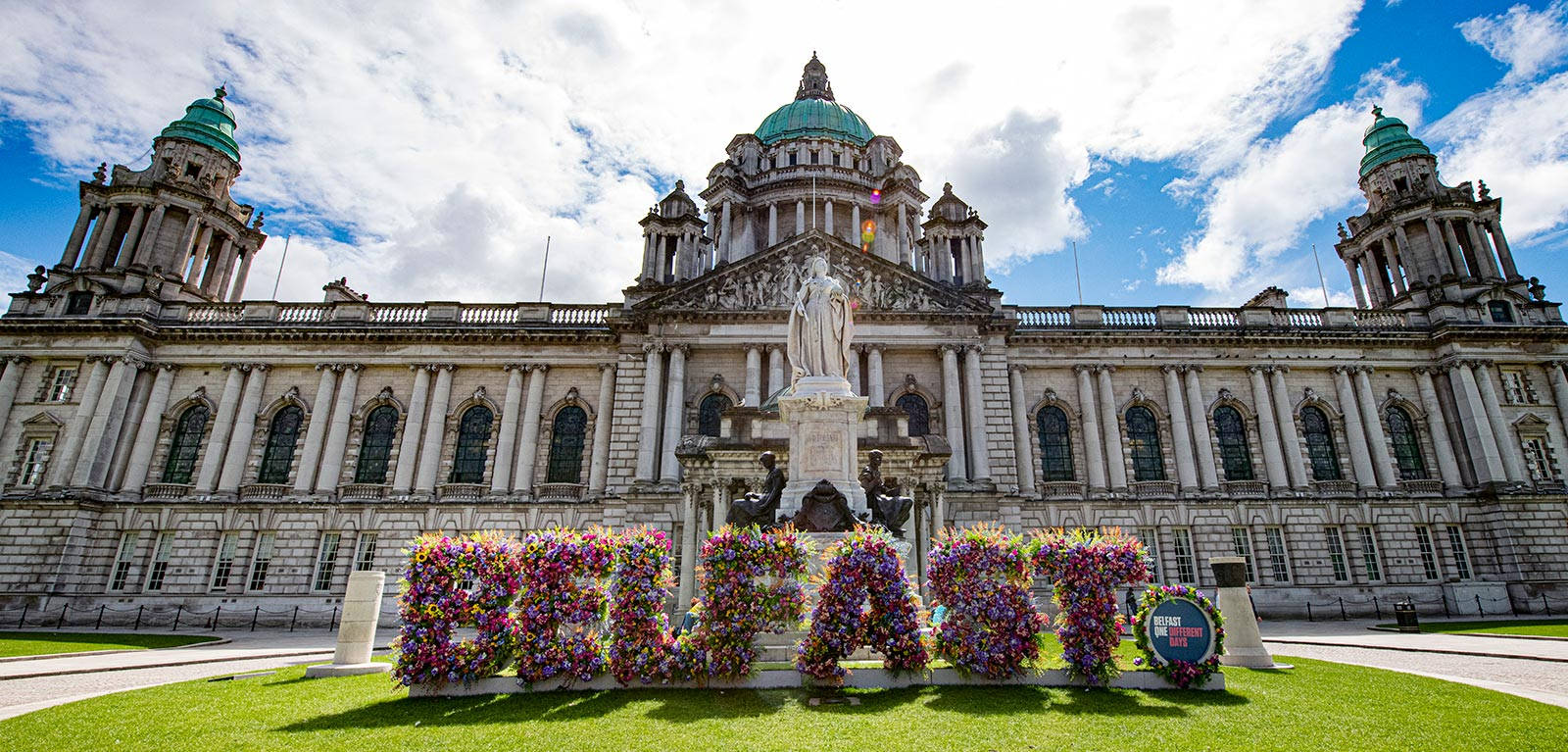 A Large Building With Flowers In Front Of It Background