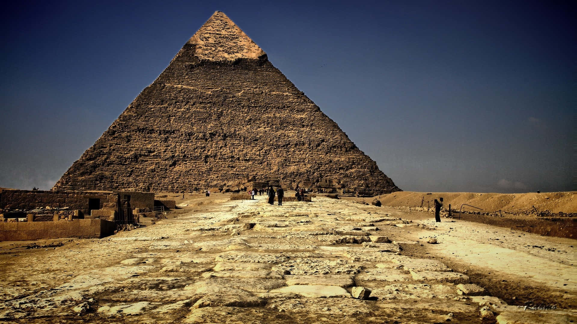 A Large Pyramid With People Walking Around It Background