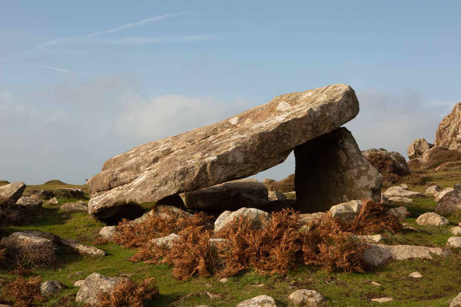 A Large Rock Formation On A Grassy Hill Background