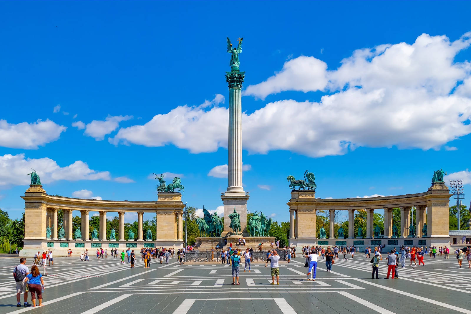 A Large Square With People Walking Around A Monument