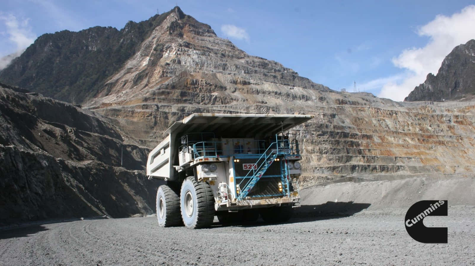 A Large Truck Driving Through A Mine Background