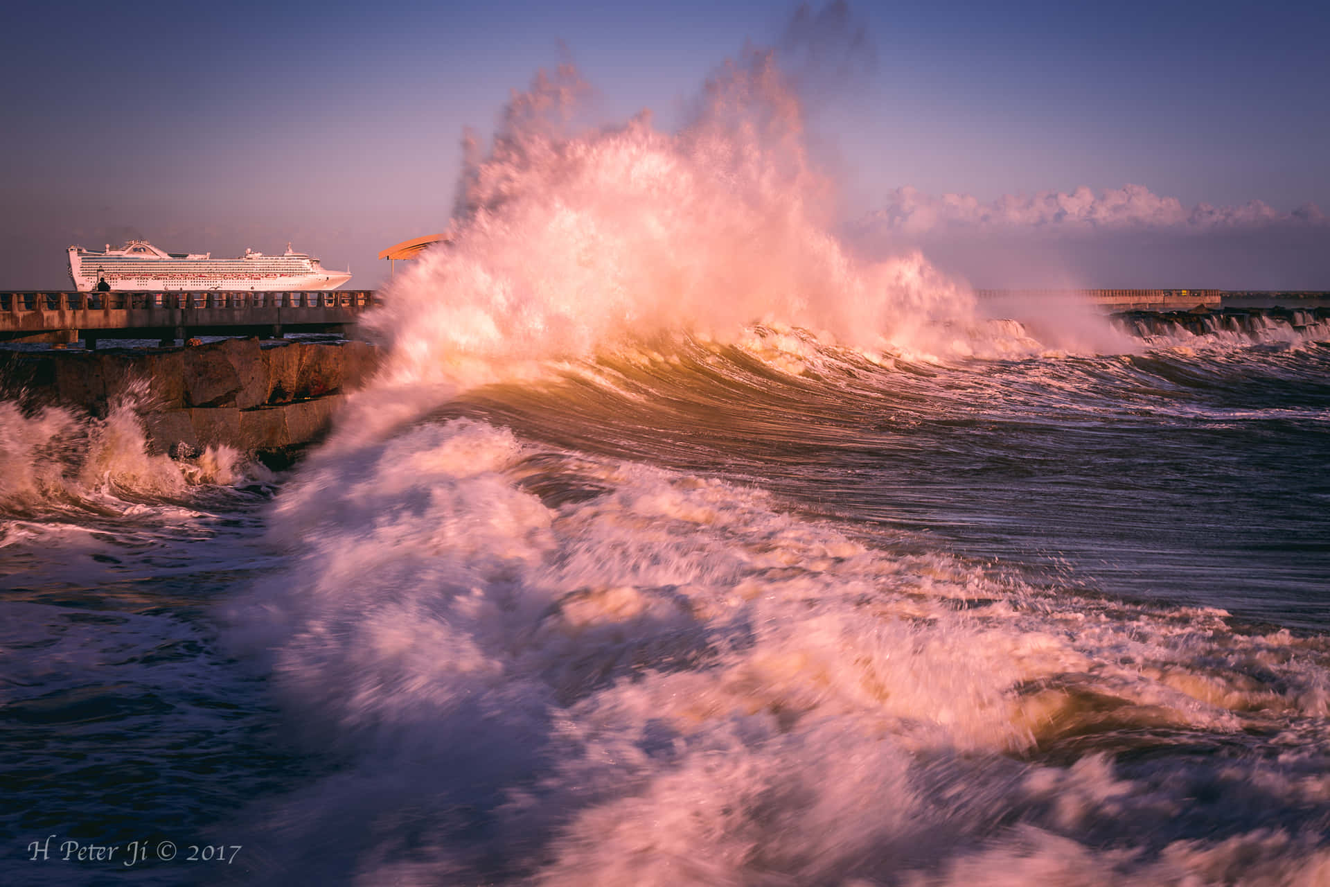 A Large Wave Crashing Into The Shore Background