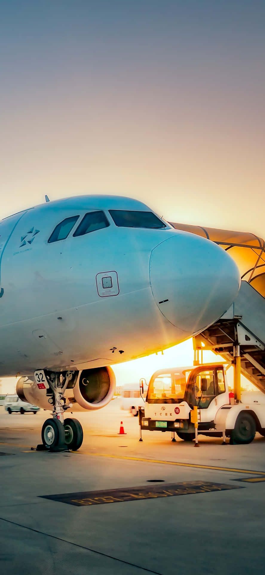 A Large White Airplane Is Parked At An Airport Background