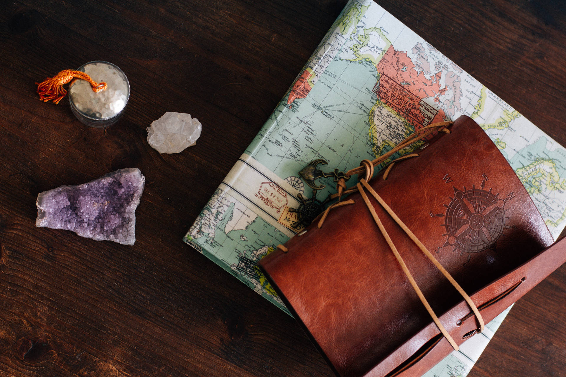 A Leather Book With A Map And A Rock Background