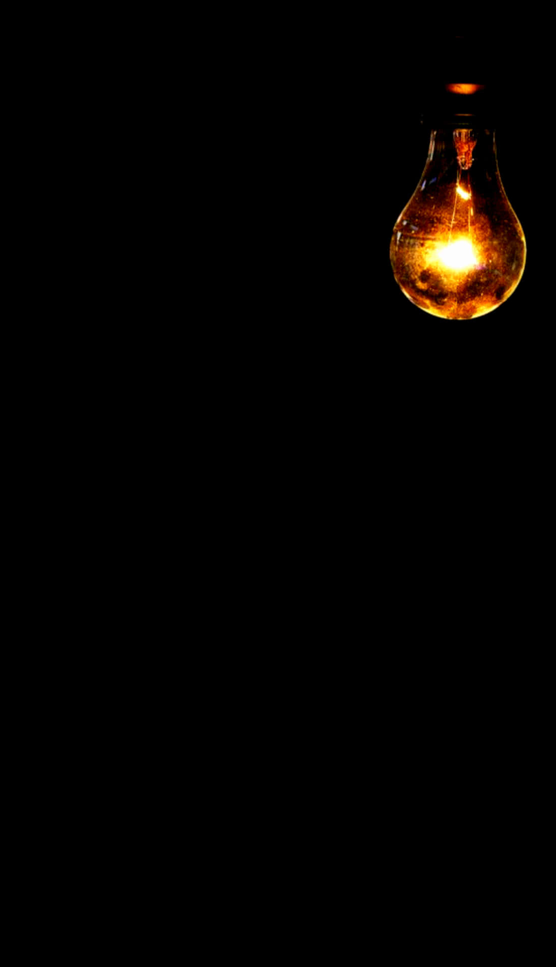 A Light Bulb Is Lit Up In The Dark Background