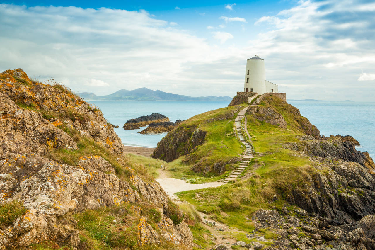 A Lighthouse On A Rocky Cliff Overlooking The Ocean