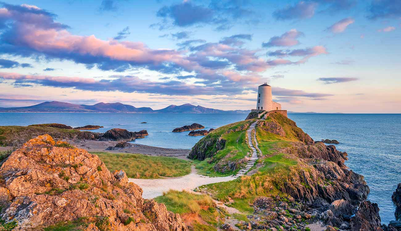 A Lighthouse Sits On Top Of A Rocky Cliff