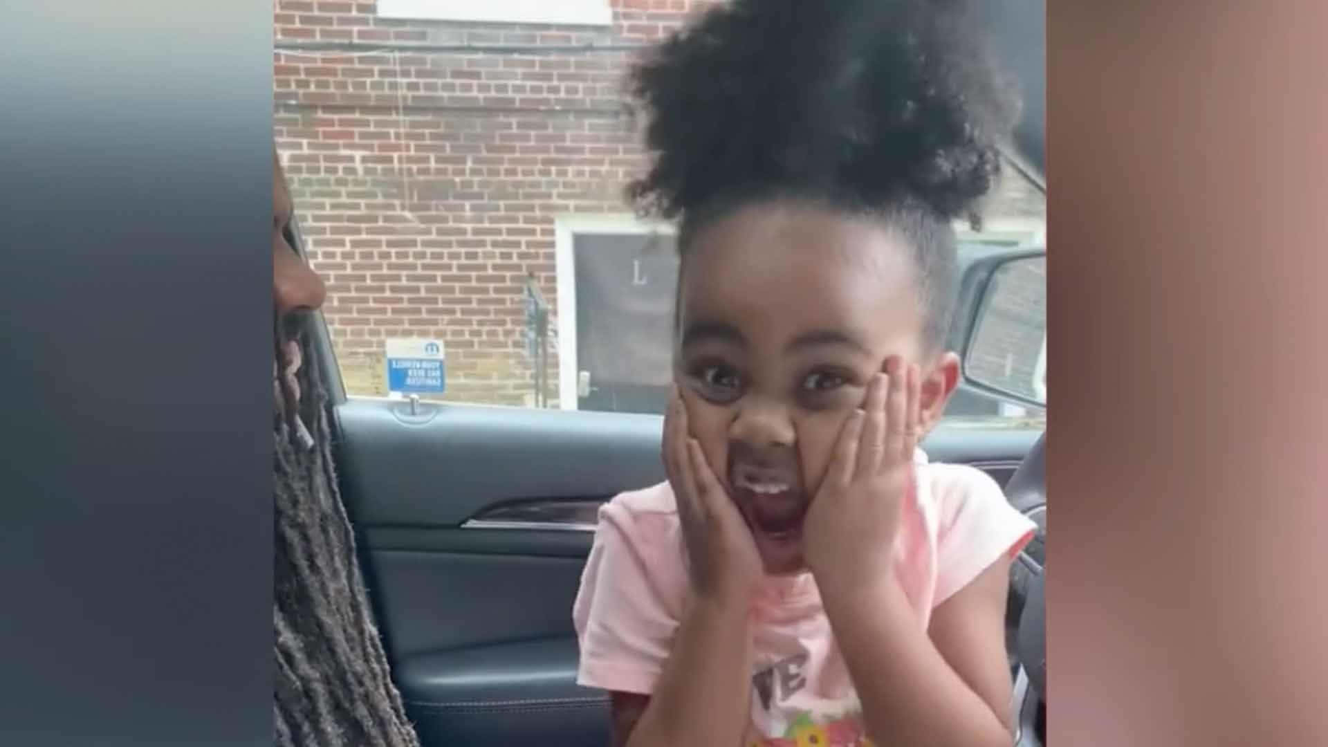 A Little Girl Is Laughing While Sitting In The Car Background