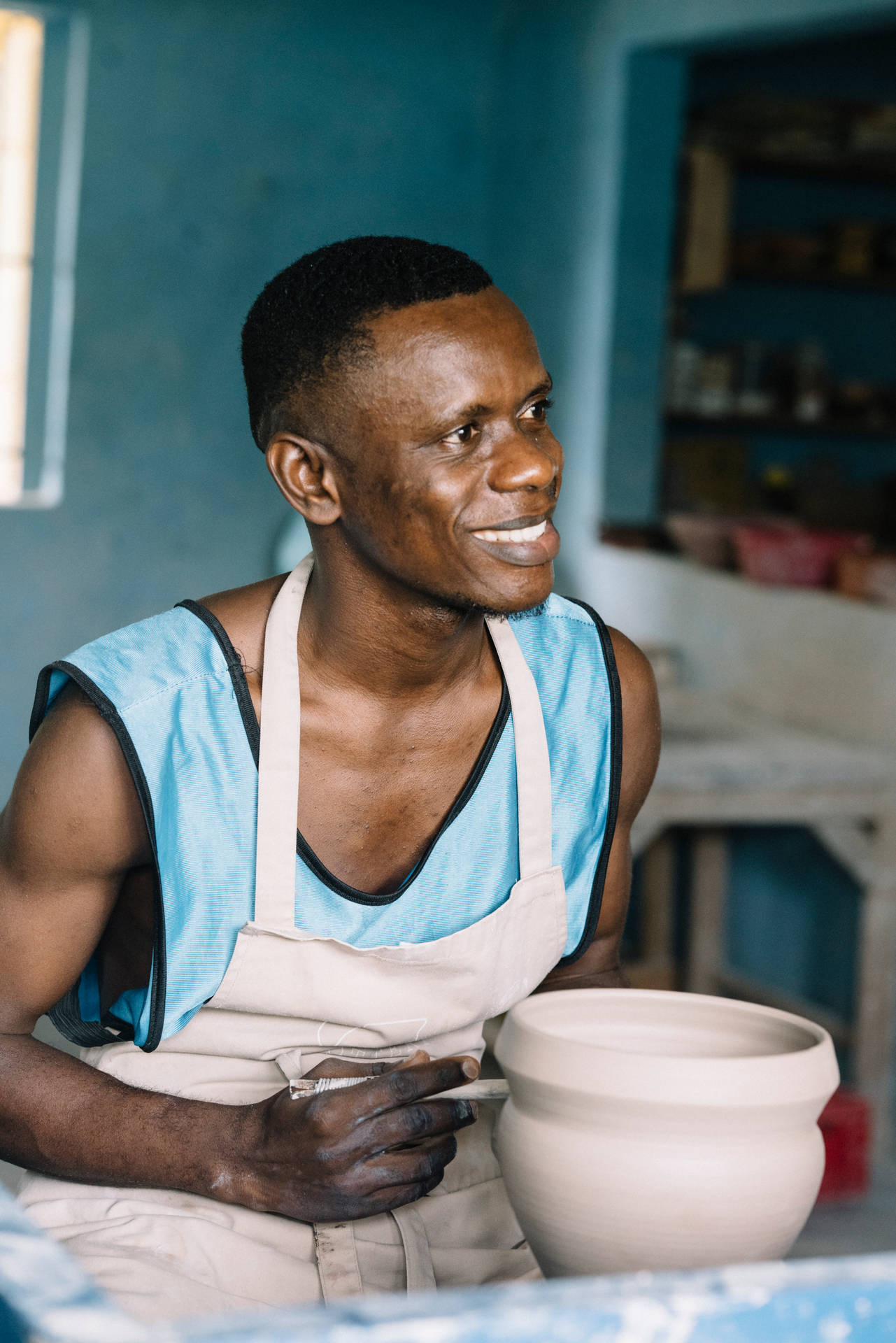 A Local Artisan Shaping Pottery In Sierra Leone Background