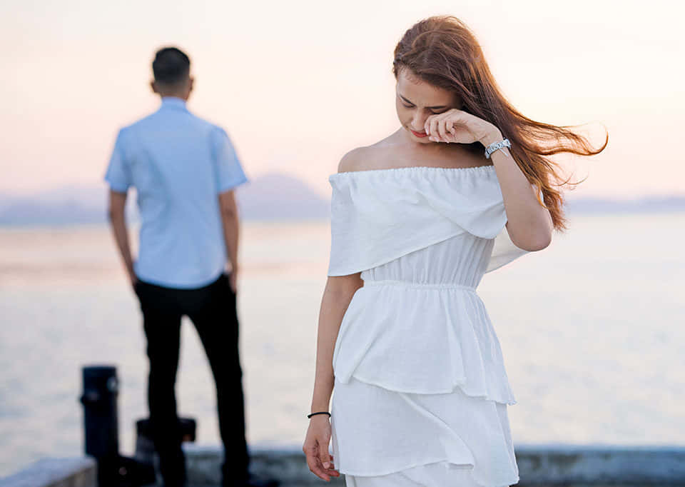 A Lone Figure Stands Isolated And Still In The Midst Of A Crowd Background