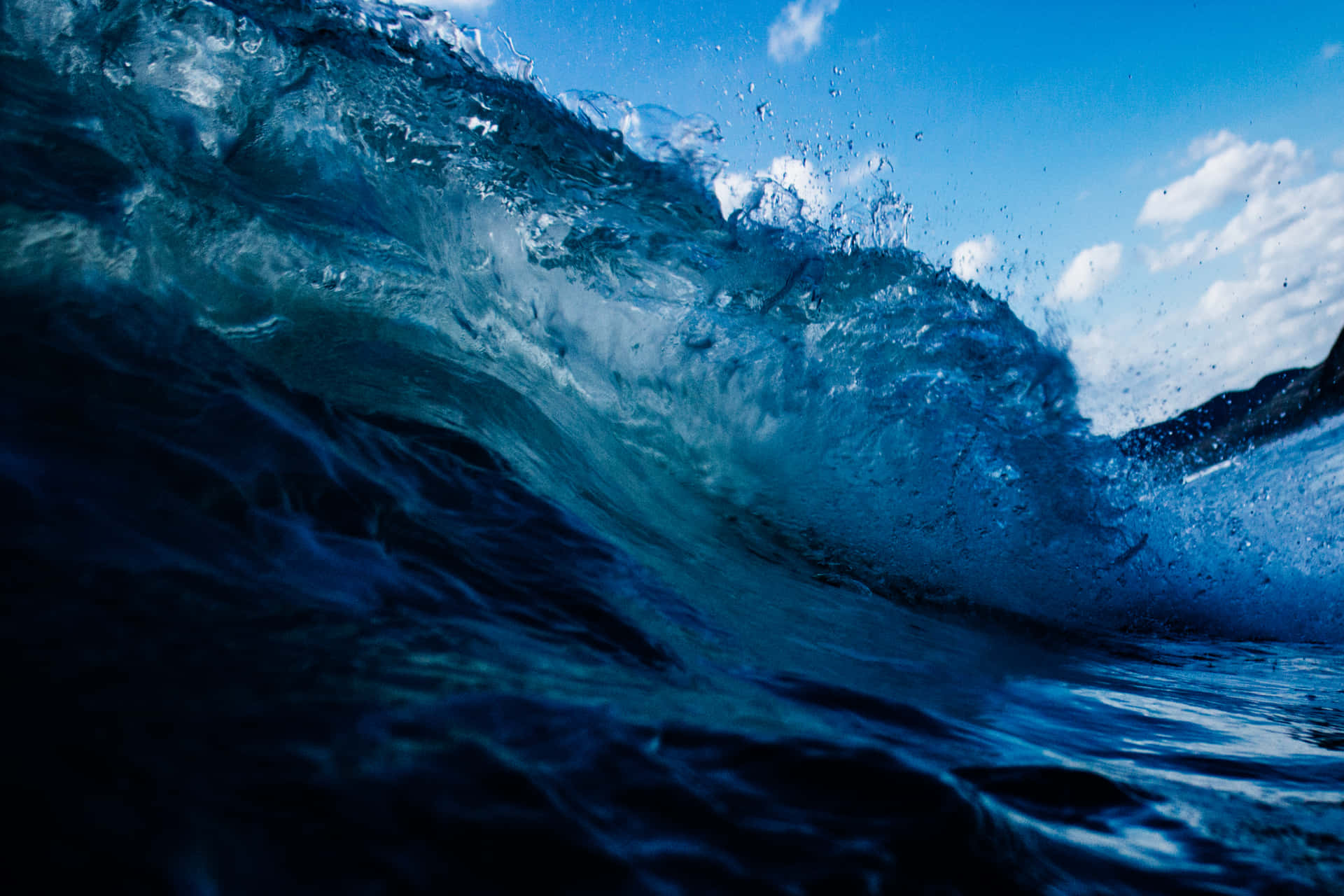 A Lone Surfer Overwhelmed By Powerful Waves Background