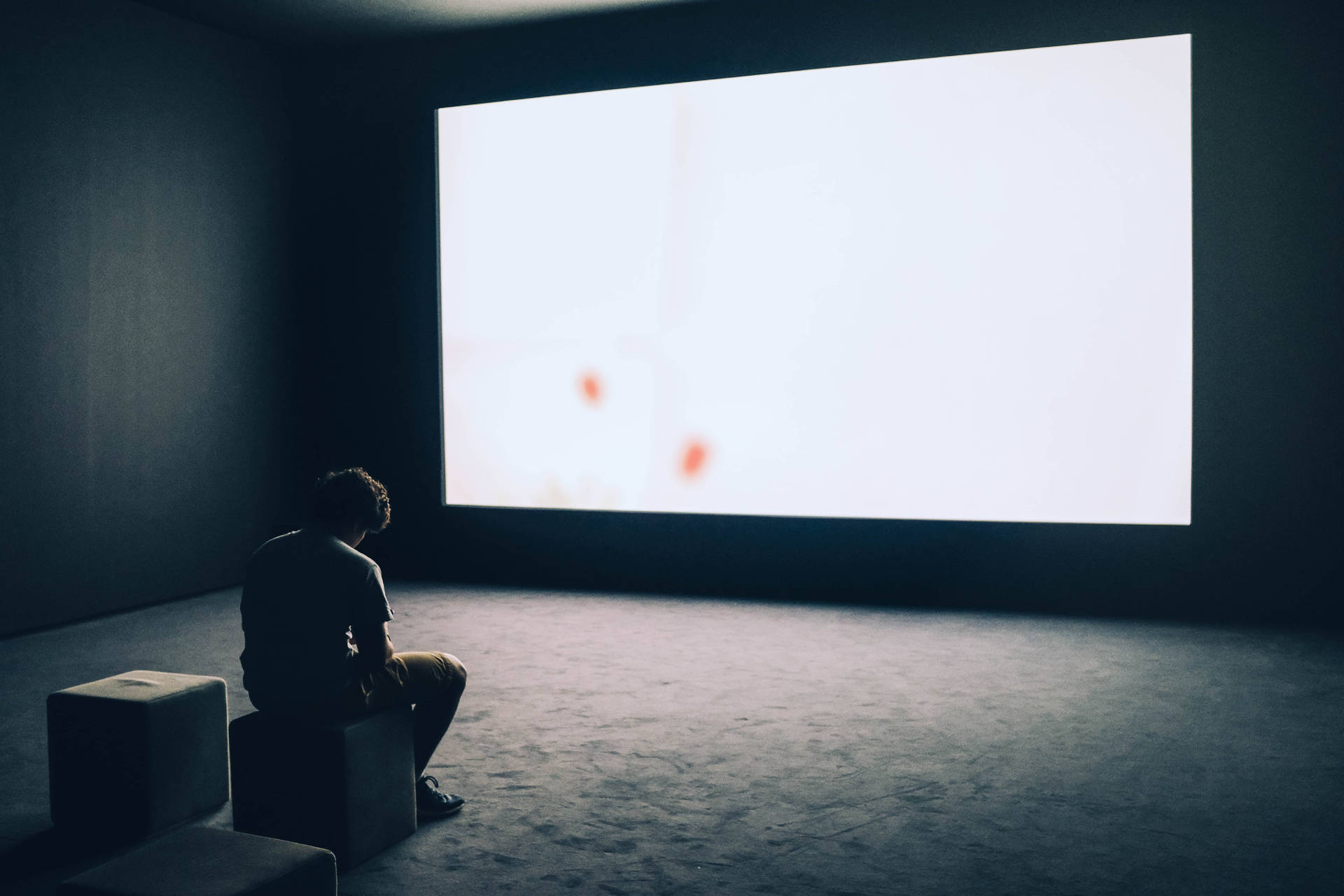 A Lonely Reflection: Man Sitting Alone In Theater Room Background