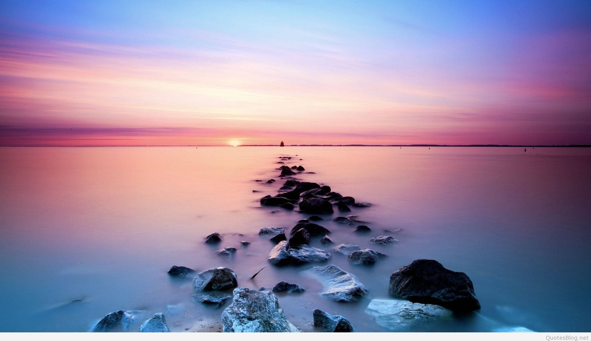 A Long Exposure Of Rocks And Water At Sunset Background