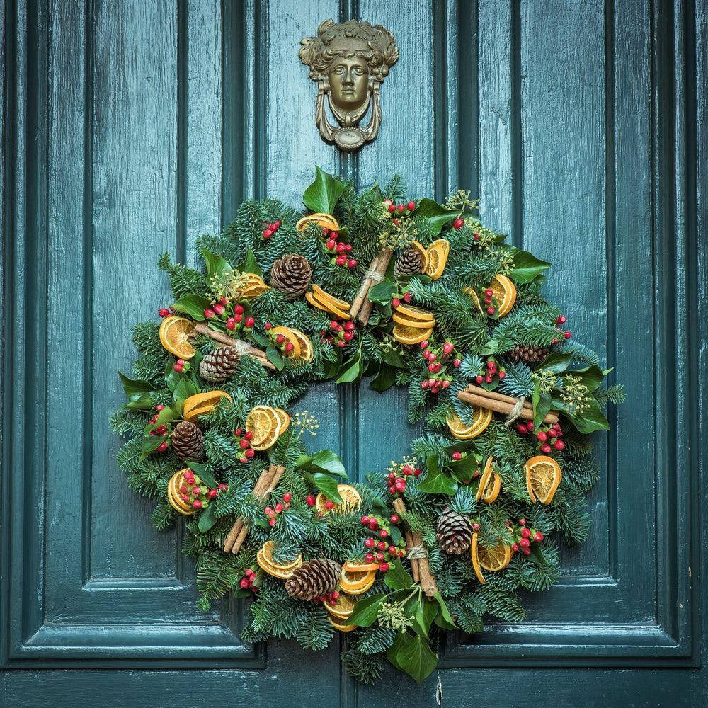 A Lovely Christmas Wreath Garnished With Zesty Orange Slices Background