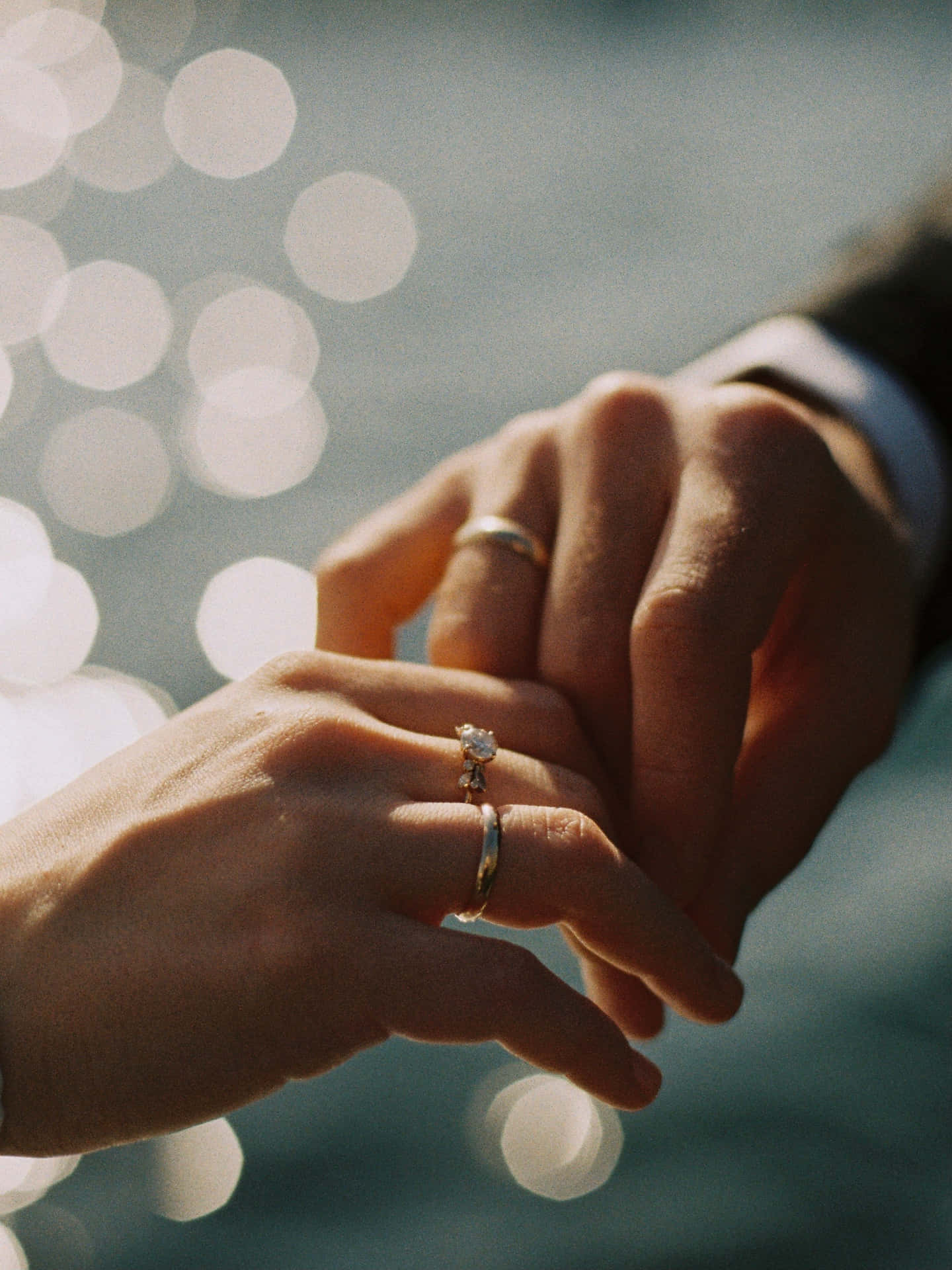 A Loving Embrace Between Husband And Wife, Featuring Their Wedding Rings Background