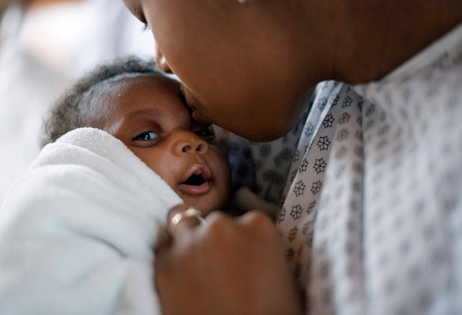 A Loving Moment Between A Smiling Mother And Her Swaddled Baby Background