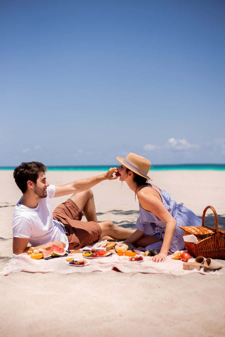 A Loving Moment: Couple Enjoying A Relaxing Picnic On The Beach Background