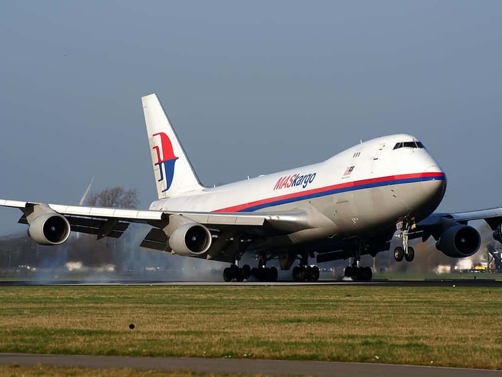 A Majestic Jumbo Jet Soaring Through The Sky Background