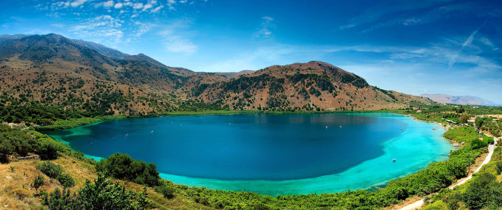 A Majestic Mountain Lake Fills Up The Horizon On A Sunny Day. Background