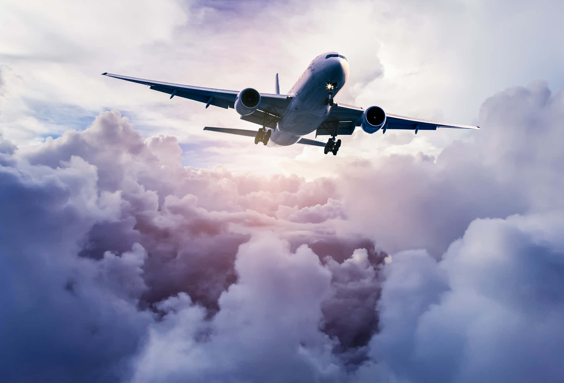 A Majestic Passenger Airplane Soars Through The Clouds Background