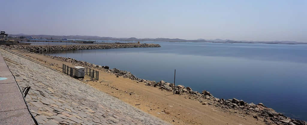 A Majestic View Of The Pervading Aswan High Dam Riverside Background
