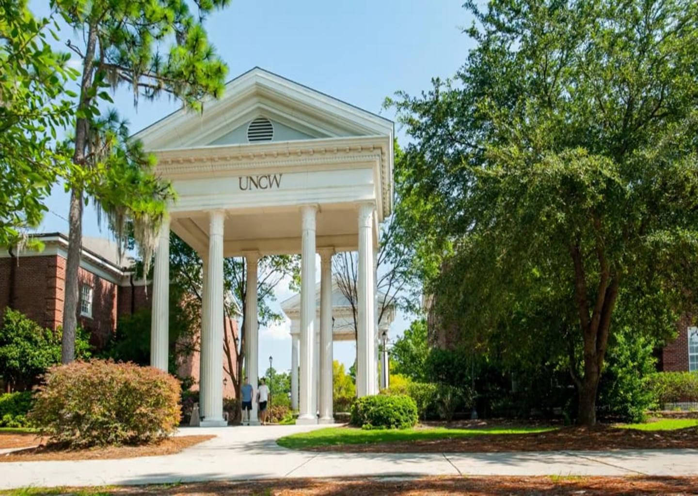 A Majestic White Colonnade Arch At University Of North Carolina Wilmington Background