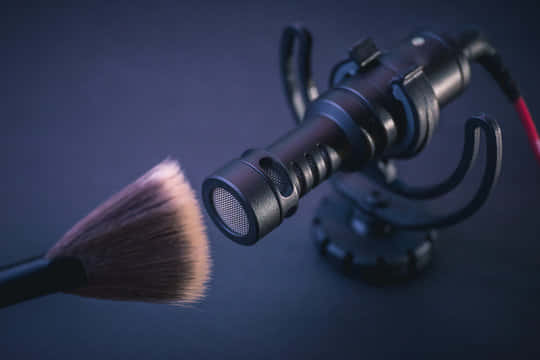 A Makeup Brush Is Placed On A Microphone