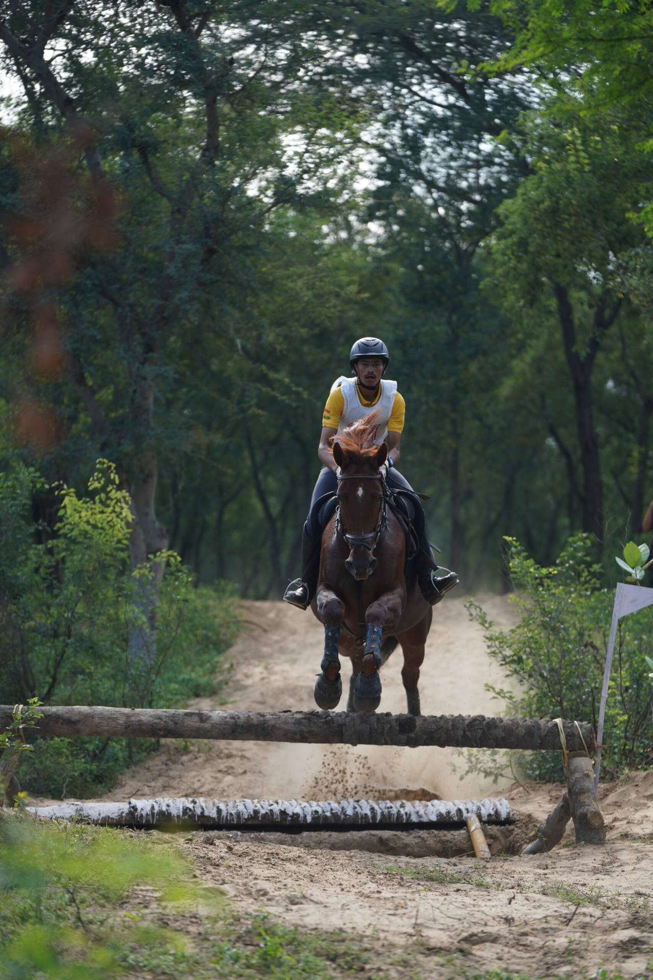 A Male Equestrian Practicing Horseback Riding Through Field