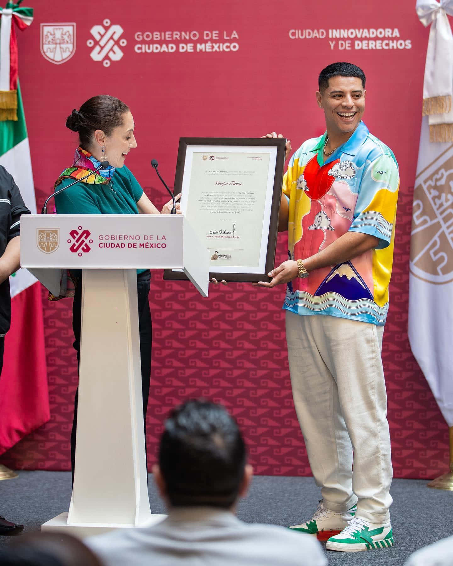 A Man And Woman Are Standing At A Podium With A Certificate Background