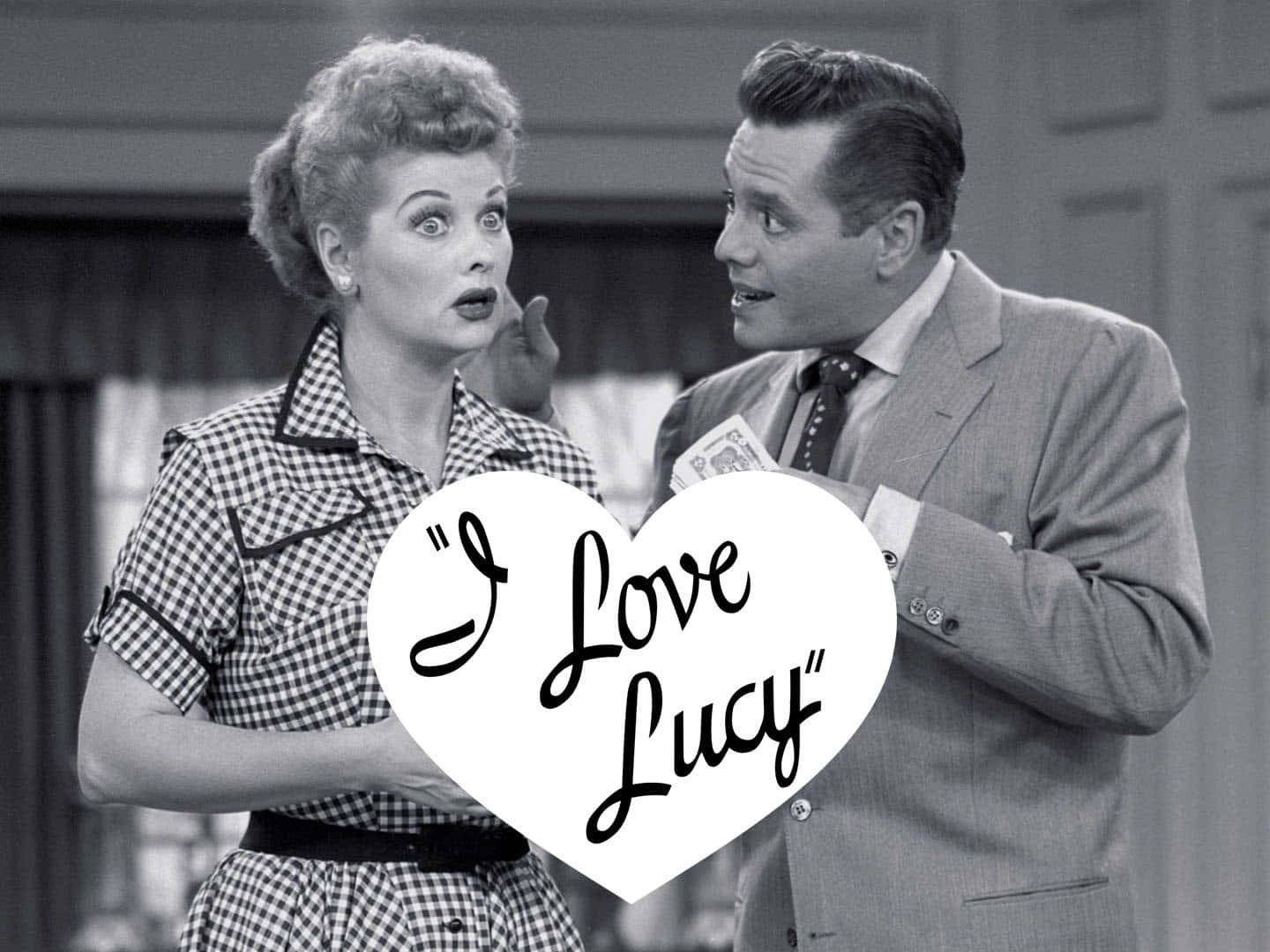 A Man And Woman Holding A Sign That Says I Love Lucy