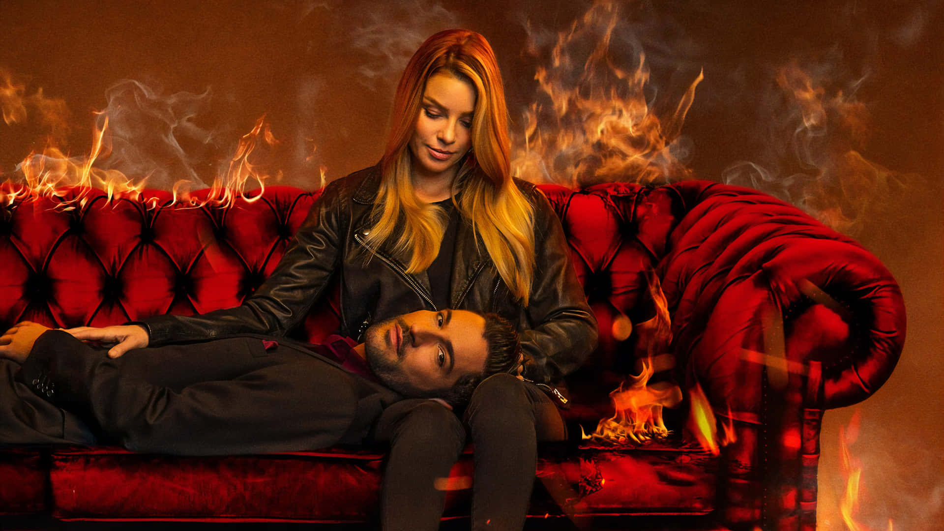 A Man And Woman Laying On A Red Couch With Fire Background