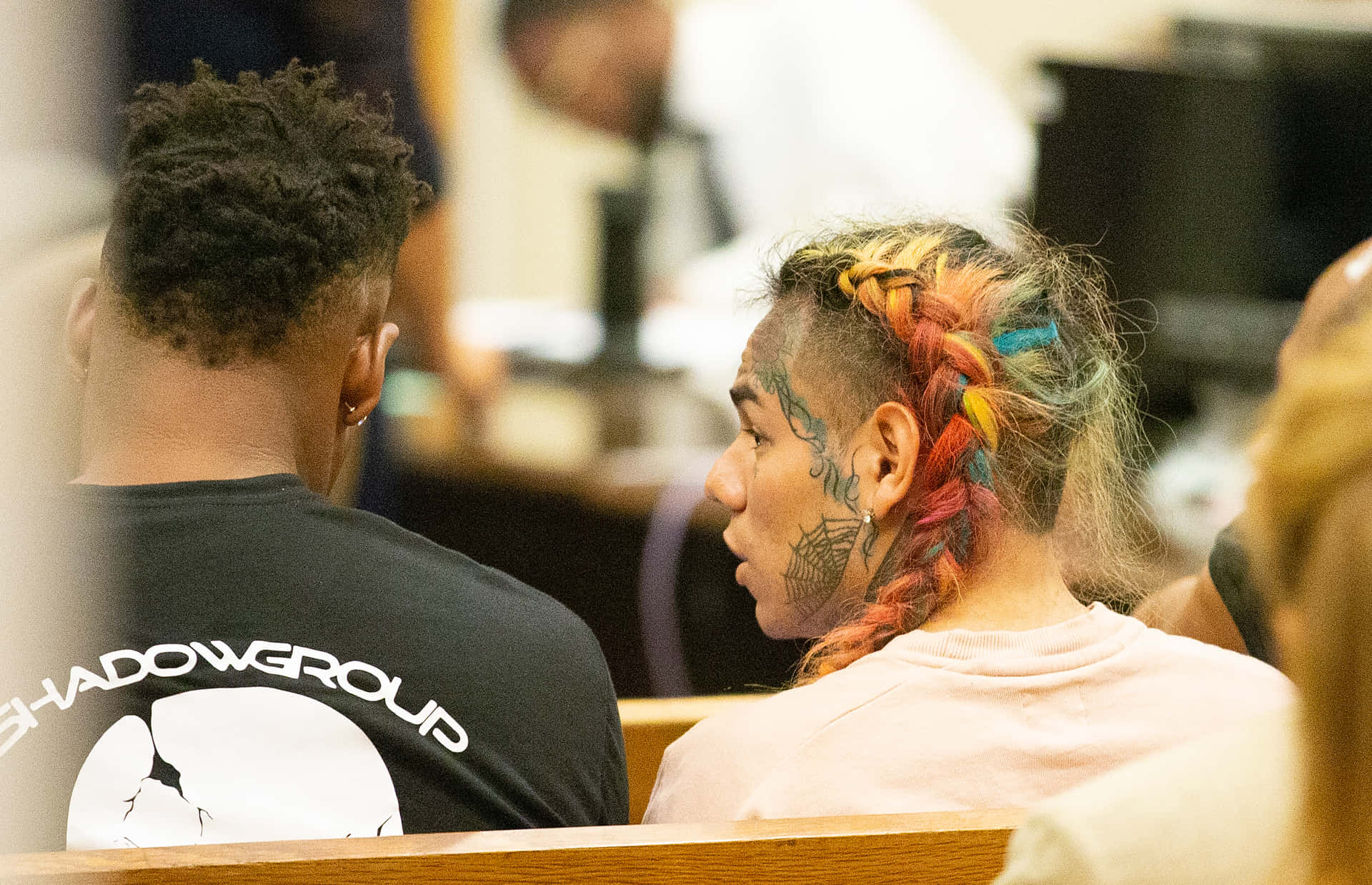 A Man And Woman Sitting In A Courtroom Background