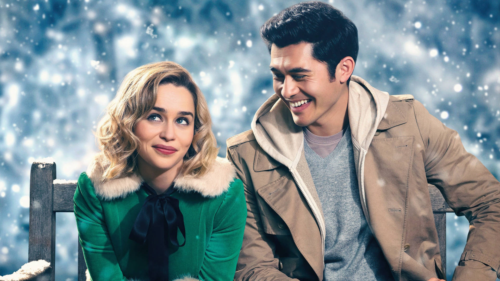 A Man And Woman Sitting On A Bench In The Snow