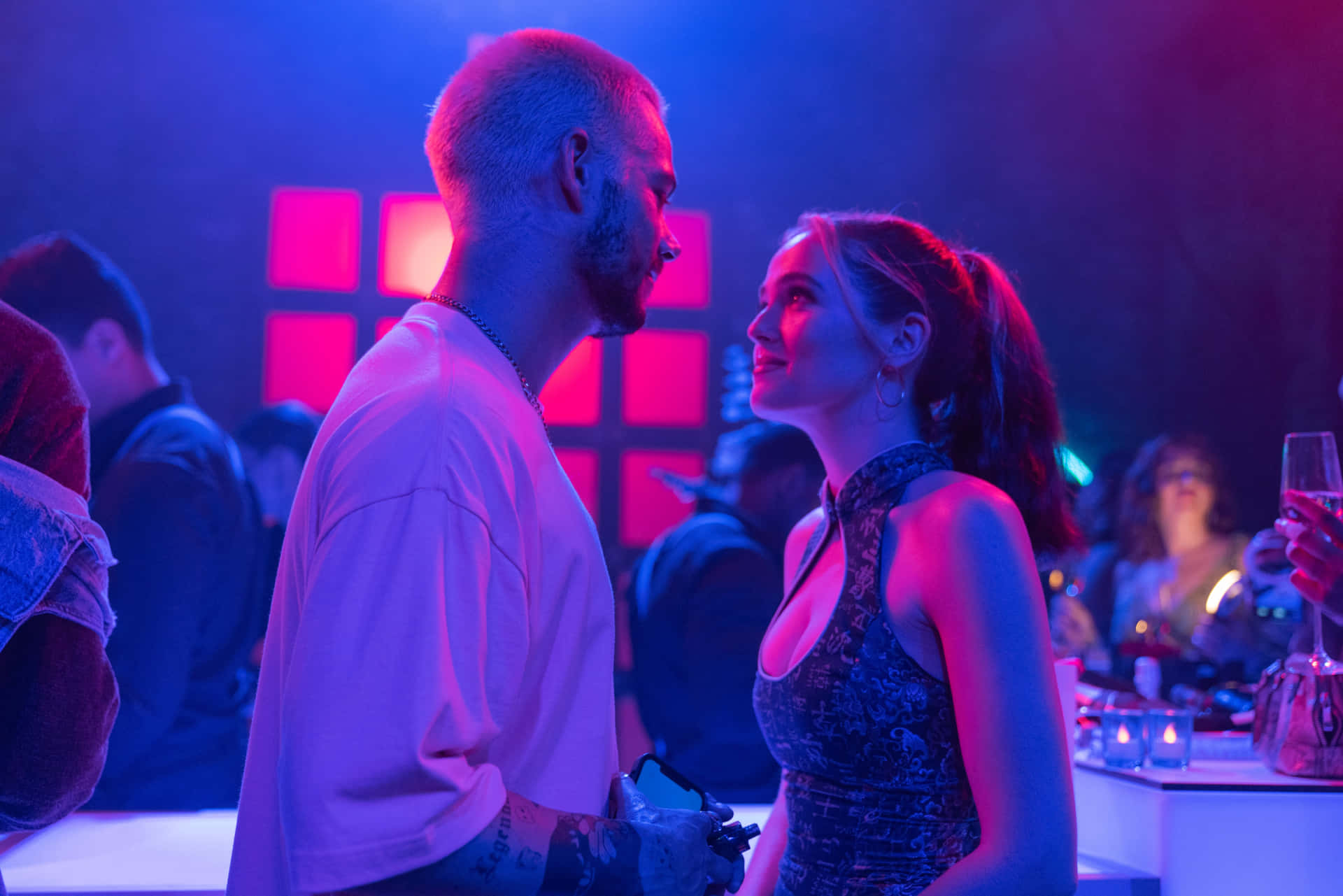 A Man And Woman Standing In A Club Background