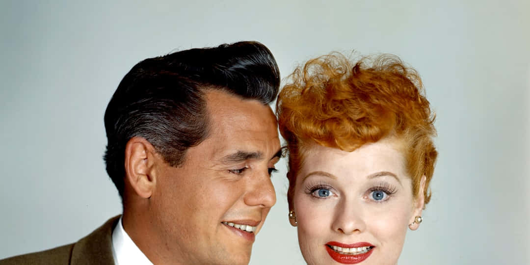 A Man And Woman With Red Hair Are Smiling Background