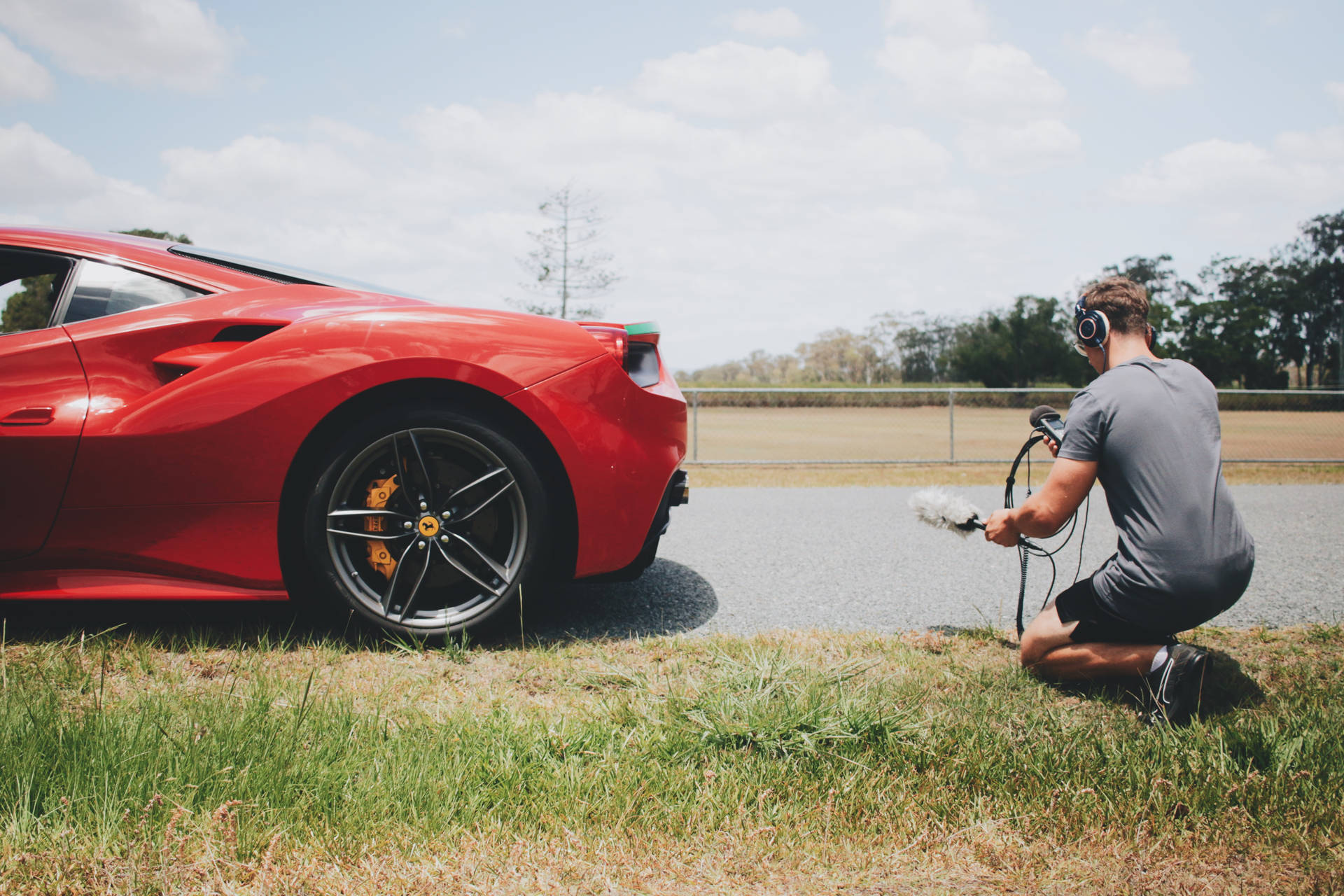 A Man Driving A Red Ferrari Background