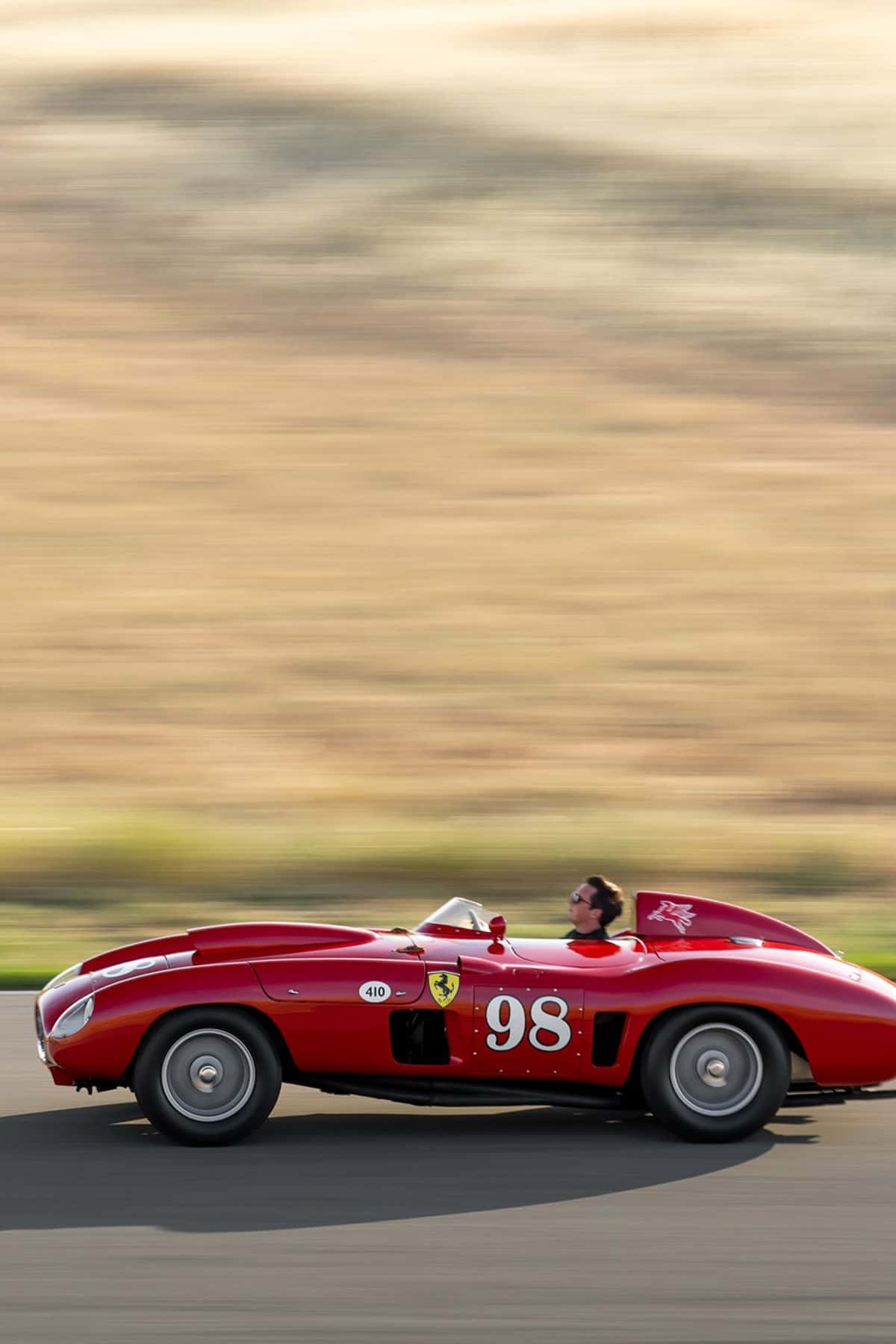 A Man Driving A Red Racing Car On A Track