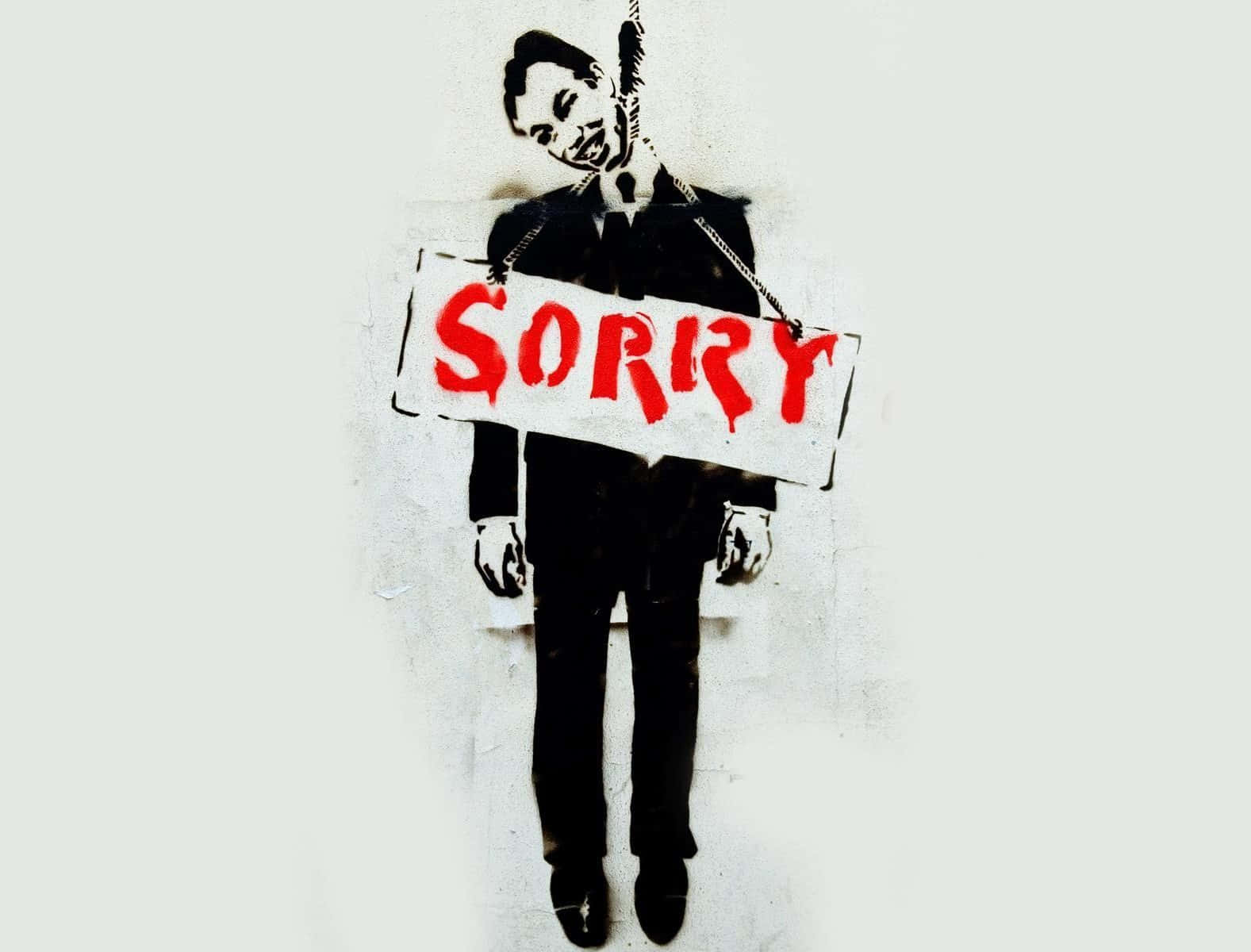 A Man Holding A Sign That Says Sorry