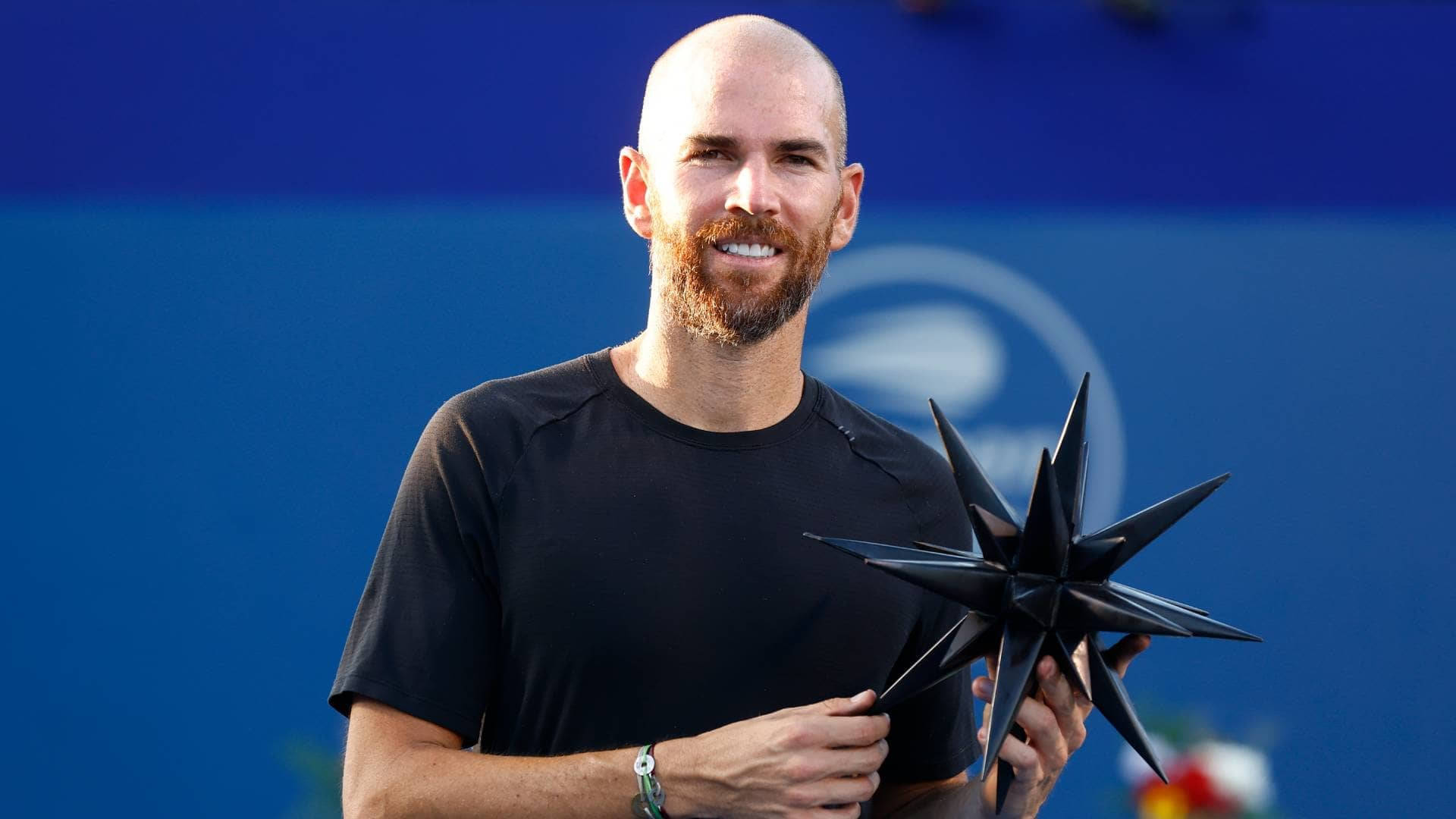 A Man Holding A Star On A Tennis Court