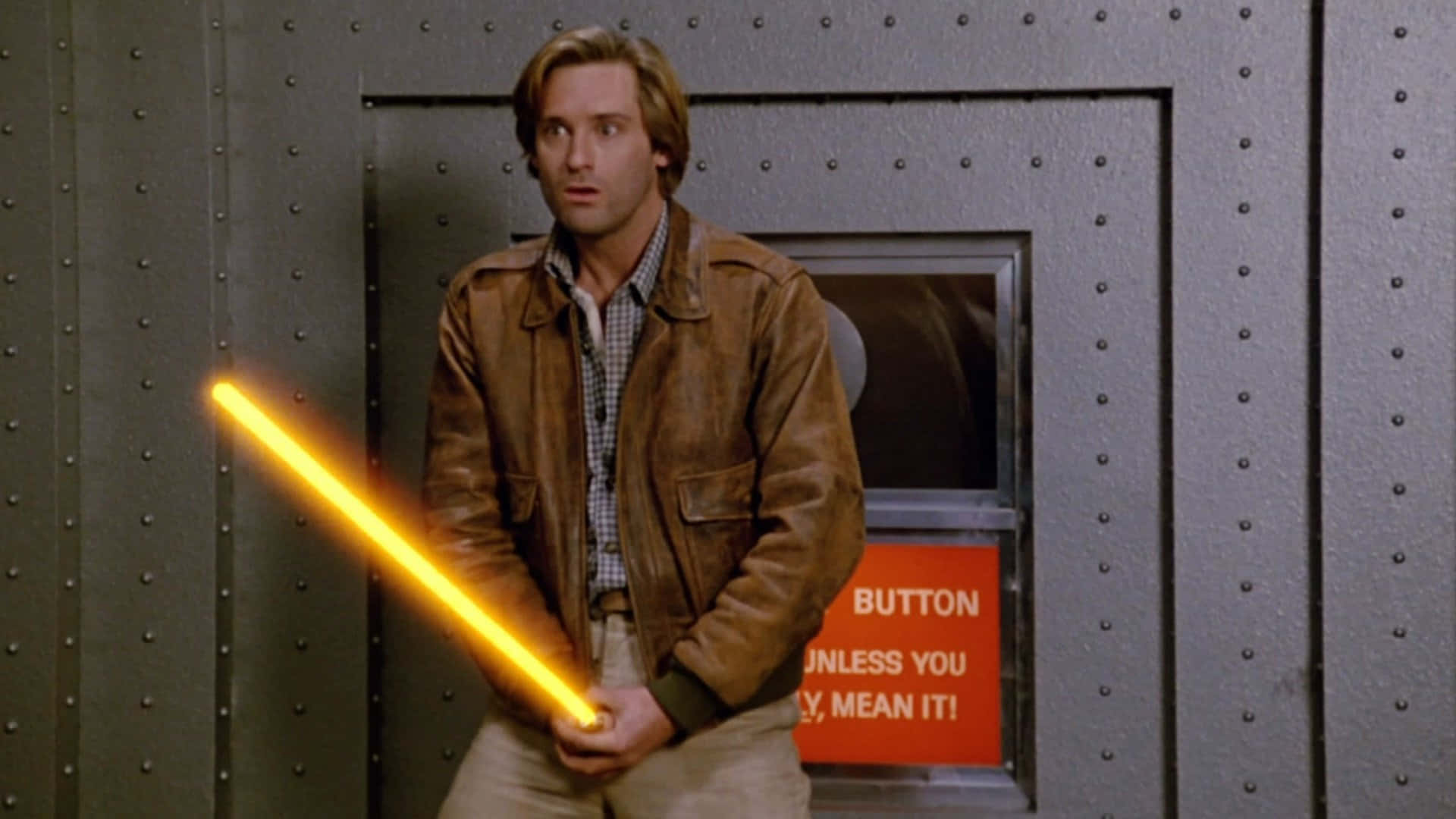 A Man Holding A Yellow Light Saber In Front Of A Door Background