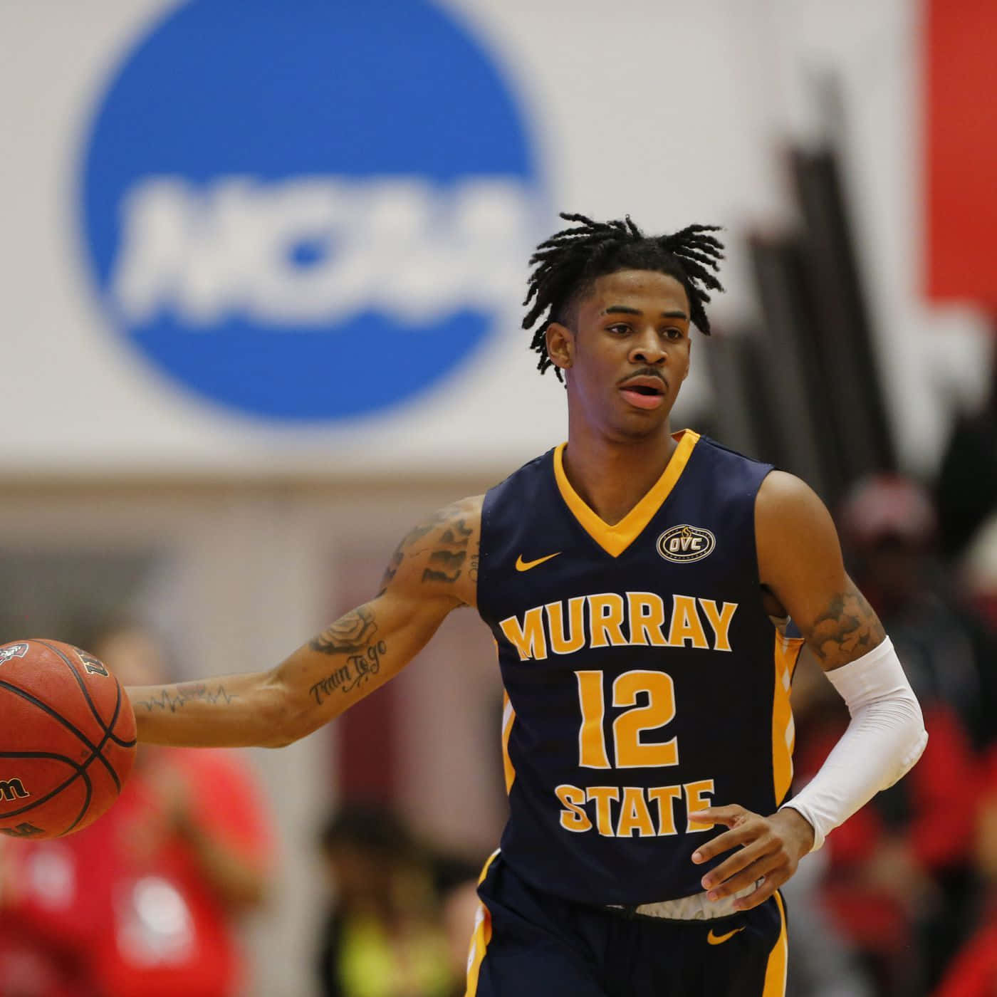 A Man In A Basketball Uniform Dribbling A Ball Background