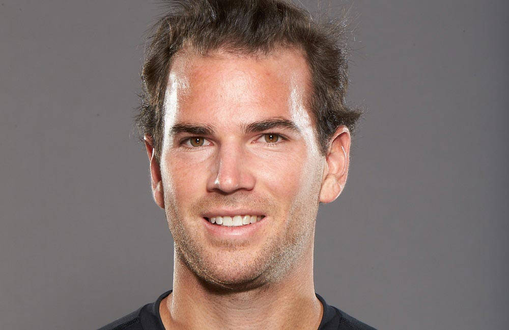 A Man In A Black Shirt Is Smiling For The Camera Background