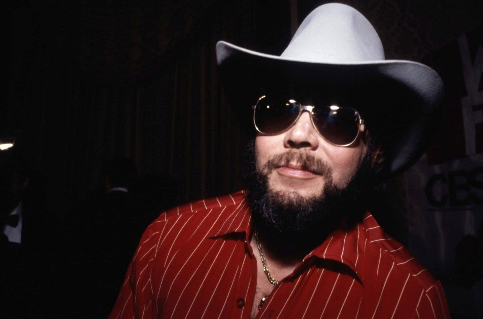 A Man In A Cowboy Hat And Sunglasses