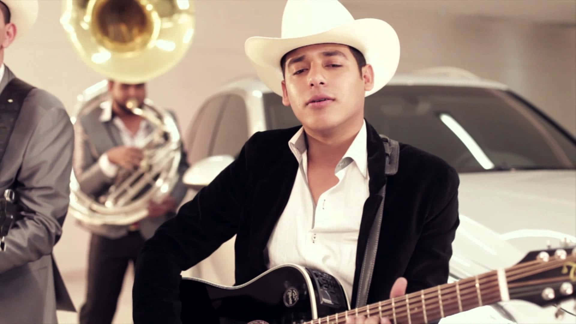 A Man In A Cowboy Hat Plays An Acoustic Guitar Background