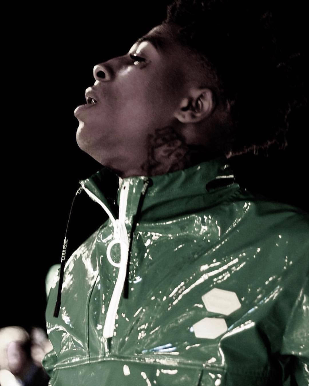 A Man In A Green Jacket With Dreadlocks Background