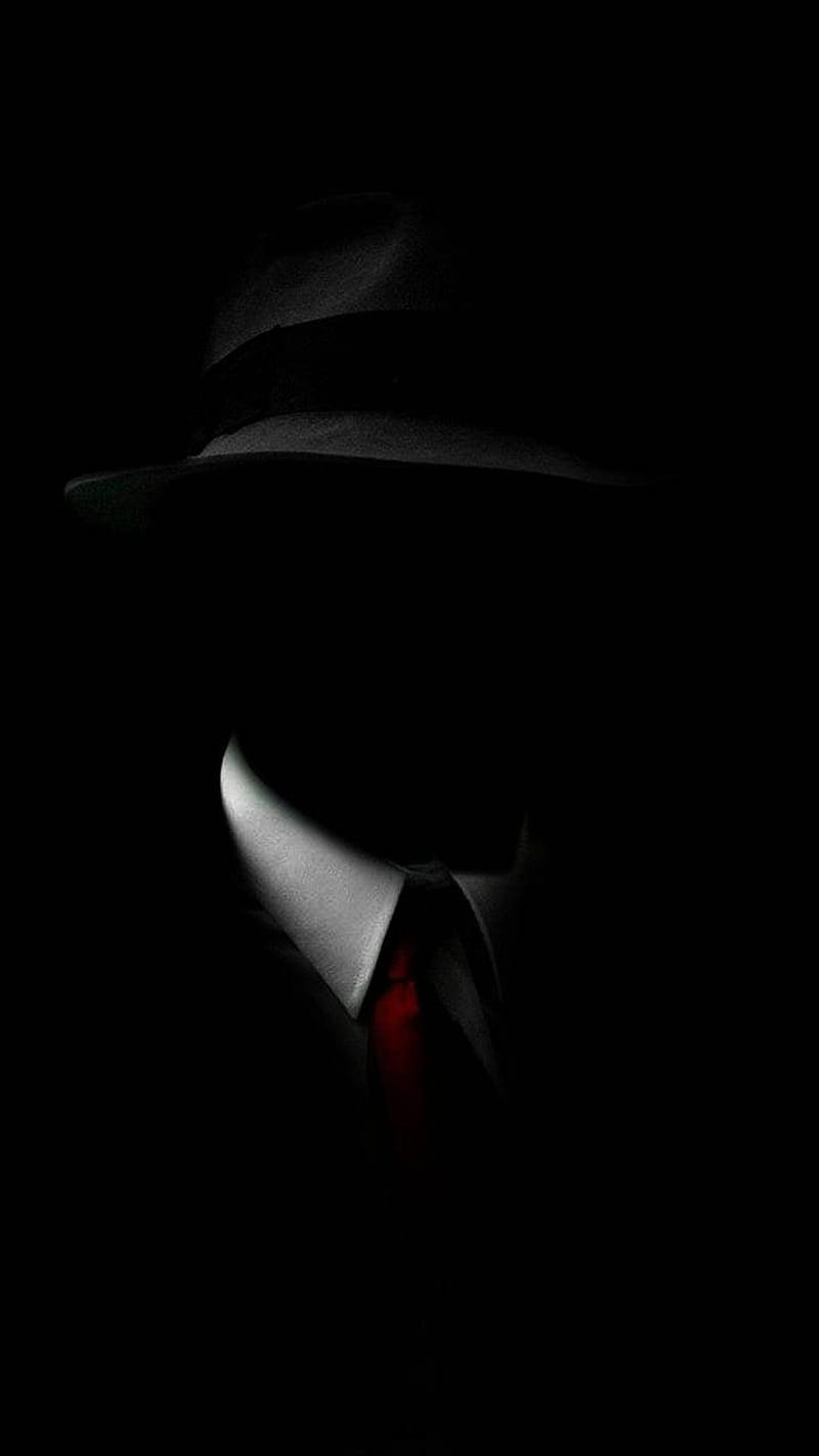 A Man In A Hat And Tie In The Dark Background