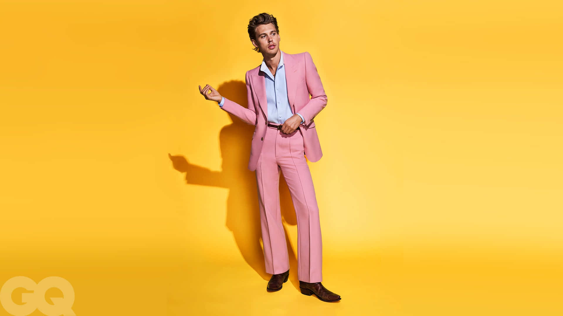 A Man In A Pink Suit Posing Against A Yellow Background Background