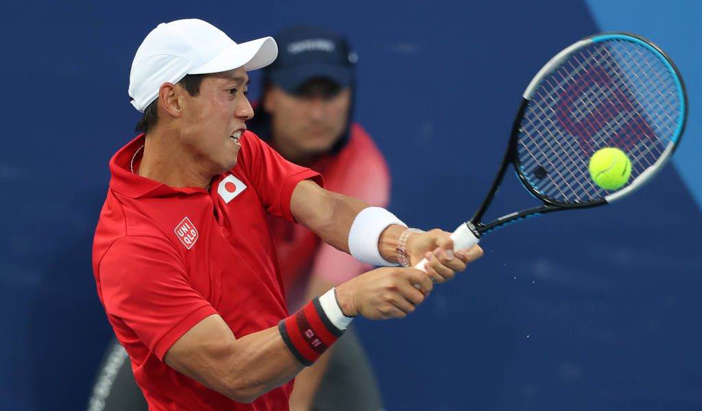 A Man In A Red Shirt Is Hitting A Tennis Ball Background